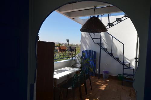 a room with a balcony with a table and chairs at Les appartements de la Villa Beida in Oualidia