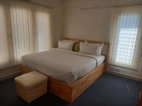 een slaapkamer met een groot bed en 2 ramen bij Windfall Service Apartment in Bangalore