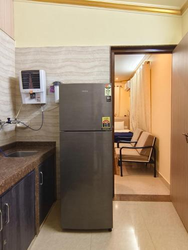 a kitchen with a refrigerator and a living room at Shraddha hospitality in Calangute