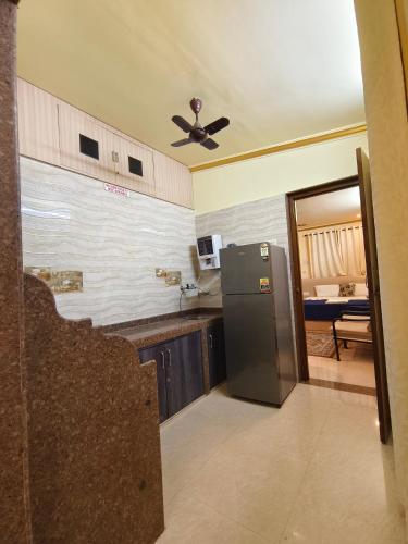 a kitchen with a refrigerator and a ceiling fan at Shraddha hospitality in Calangute