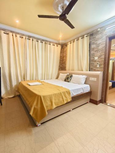 a bedroom with a bed with a ceiling fan at Shraddha hospitality in Calangute