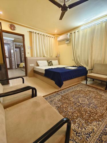 a bedroom with a bed and a couch and a mirror at Shraddha hospitality in Calangute