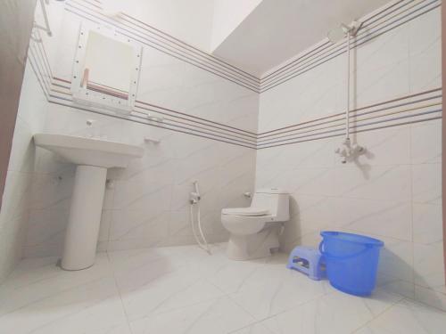 Karachi Motel Guest House في كراتشي: حمام ابيض مع مرحاض ومغسلة