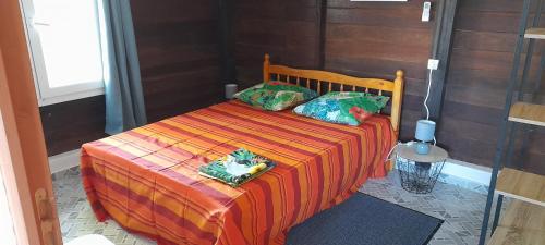 ein Bett mit zwei Kissen auf einem Zimmer in der Unterkunft Fred'lodge in Matoury