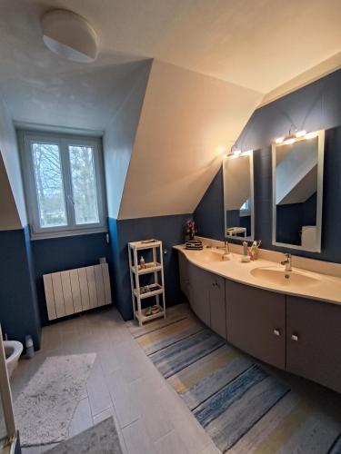 ein Badezimmer mit zwei Waschbecken und zwei Spiegeln in der Unterkunft Etage complet in Gouvieux