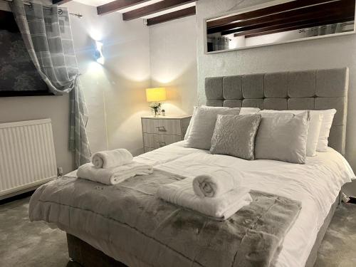 a bedroom with a large bed with towels on it at Duchess Apartments Modern 3Bedroom Apartment in Colchester Ideal for Long Stays, Relocations, Contractors, Secure Parking, WIFI in Colchester