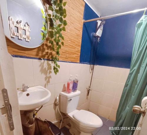 W łazience znajduje się toaleta, umywalka i lustro. w obiekcie Mamby Gray's Place Balcony, Karaoke ,Wifi,Netflix &Kitchen w mieście Imus
