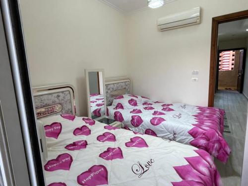 a bedroom with two beds with hearts on the sheets at بورتو جولف مارينا in Abû Zeira