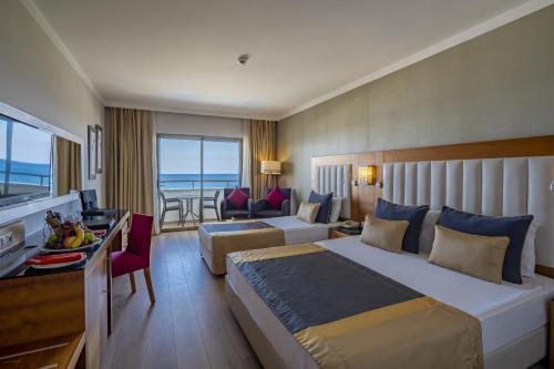 a hotel room with a bed and a living room at Sunland Resort Beldibi in Kemer