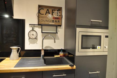 une cuisine avec un évier et un micro-ondes dans l'établissement la traverse, à Sarlat-la-Canéda