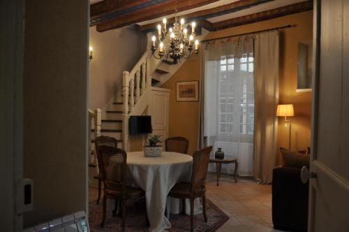 une salle à manger avec une table et un lustre dans l'établissement la traverse, à Sarlat-la-Canéda