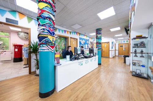 a lobby of a store with a woman at a counter at Pax Lodge in London