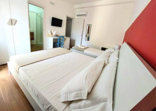 a bedroom with two white beds and a red wall at Casa sulla Punta in Marina di Camerota