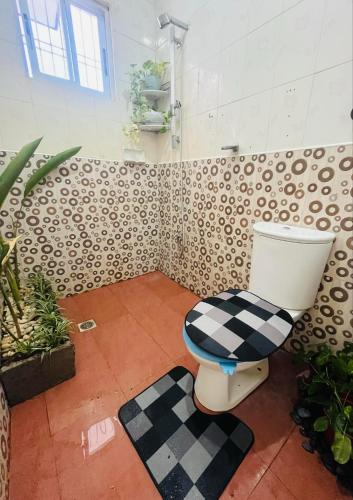 ein Badezimmer mit einem WC mit einem karierten Sitz in der Unterkunft Elle's House in Dipolog City