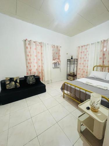 Zimmer mit 2 Betten, einem Sofa und einem Tisch in der Unterkunft Elle's House in Dipolog City