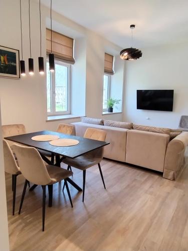 a living room with a table and a couch at Vytenio22- 2 bedrooms in Prienai
