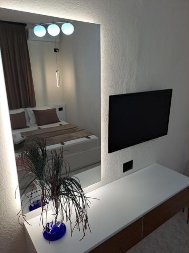 a living room with a large mirror and a tv at Manga guesthouse in Gjirokastër