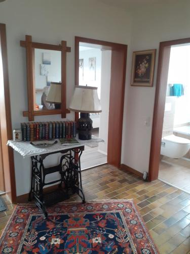 a room with a table with a lamp and a rug at Ferienwohnungen Sternenhimmel WHG 1 in Medebach