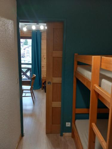 Zimmer mit 2 Etagenbetten und einer Tür in der Unterkunft Joli studio à St Gervais les bains in Saint-Gervais-les-Bains