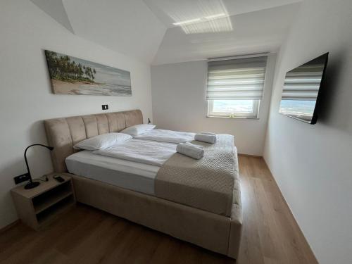 1 dormitorio con 1 cama grande y 2 ventanas en Villa ELM, en Ankaran