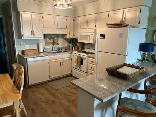 a kitchen with white cabinets and a white refrigerator at Matilda's at Ocean Forest Villas in Myrtle Beach