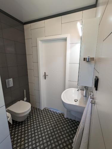 a white bathroom with a toilet and a sink at Black&White in Mrągowo