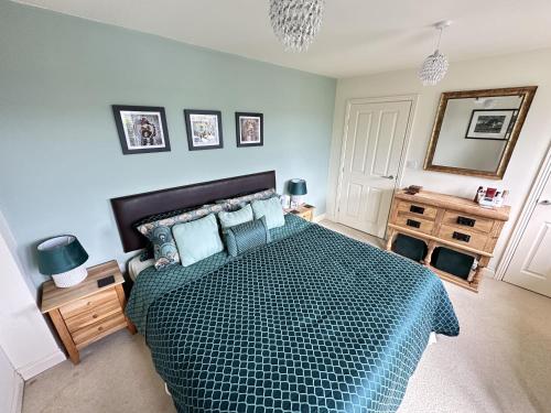 a bedroom with a bed with a green comforter at The Cosy Retreat in Filey