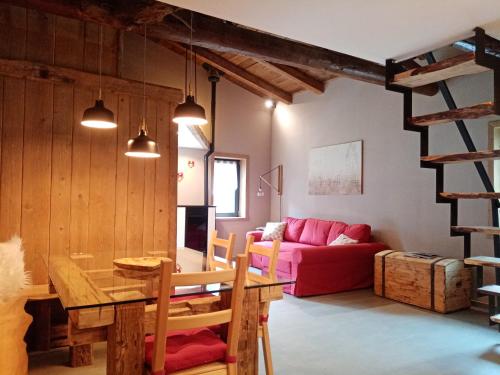- un salon avec une table et un canapé rouge dans l'établissement Il Nido, à Auronzo di Cadore