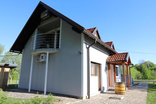 een klein wit huis met een balkon bij Apartment Filomena in Smoljanac
