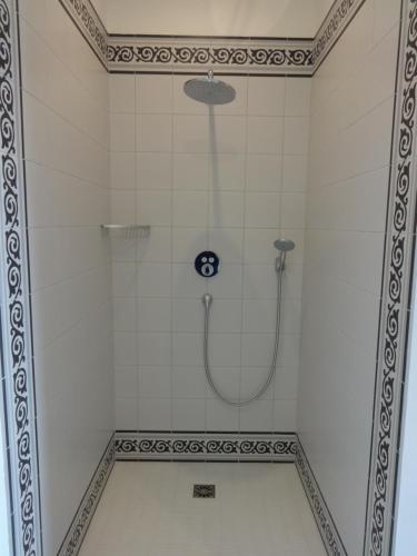 La salle de bains est pourvue d'une douche et de carrelage blanc. dans l'établissement Château Saint Georges, à Mauléon