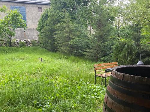a wooden bench sitting in a field of grass at guest house Telavi XXI in Tʼelavi