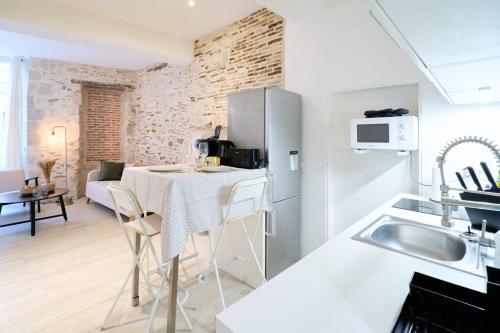 cocina y sala de estar con mesa en una habitación en La loge des Carmélites Coeur de Nantes WIFI, en Nantes