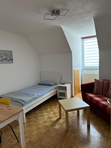 a room with a bed and a couch and a table at Ferienwohnung an der Lauchert in Gammertingen