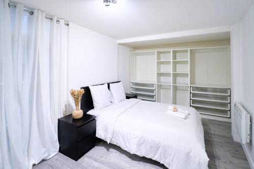 une chambre blanche avec un lit blanc et une fenêtre dans l'établissement La loge des Carmélites Coeur de Nantes WIFI, à Nantes