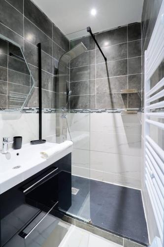 une salle de bain avec une douche en verre et un lavabo dans l'établissement La loge des Carmélites Coeur de Nantes WIFI, à Nantes