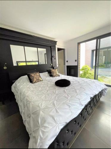 Cette chambre comprend un grand lit blanc et une grande fenêtre. dans l'établissement Summer House Vip, à Saint-Hilaire-de-Riez