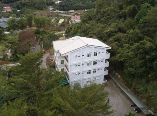 an overhead view of a white building on a hill at Taumi House in Puli