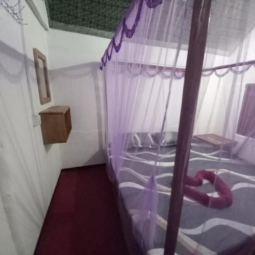 a bedroom with two bunk beds with purple curtains at Bamboo Bay in Arugam Bay