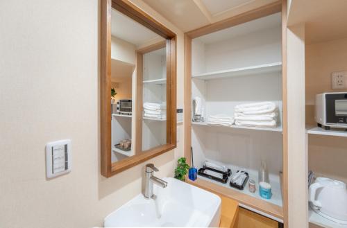 a bathroom with a sink and a mirror at New open 和風住宅 東中野駅 大久保駅徒歩圈内 新宿駅まで電車5分渋谷銀座東京近い 荷物預かります in Tokyo