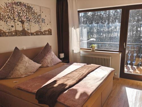 a bedroom with a bed and a large window at Hotel Waldsee in Waldachtal