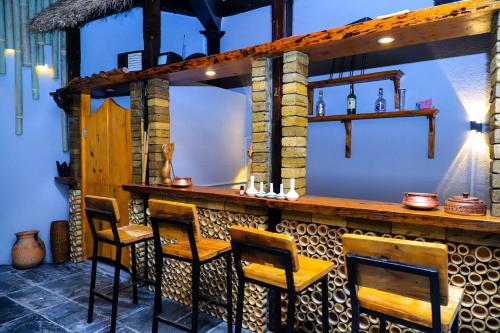 - un bar avec quatre chaises et une table dans l'établissement The Hideout Villa Pokhara, à Pokhara
