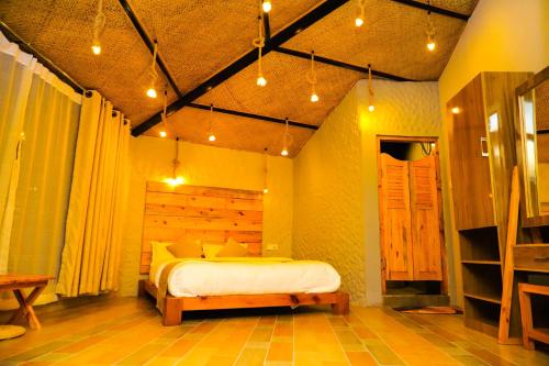 The Hideout Villa Pokhara في بوخارا: غرفة نوم فيها سرير ومقعد