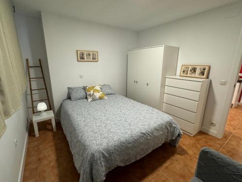1 dormitorio con 1 cama, vestidor y escalera en apartamento luanco playa, en Luanco