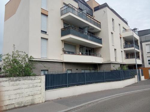 an apartment building with balconies and a fence at Chambre double 1 lit in Villepinte