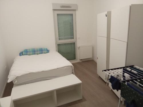 Habitación pequeña con cama y ventana en Chambre double 1 lit, en Villepinte