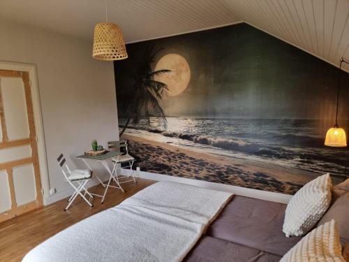 Bon Chez Nous في Saint-Amand-Jartoudeix: غرفة نوم بها لوحة كبيرة على الشاطئ