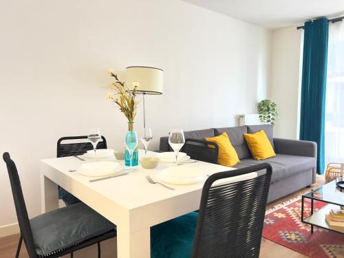 un salon avec une table et un canapé dans l'établissement Proche Paris - Appartement 2 chambres cozy et moderne, à Ivry-sur-Seine