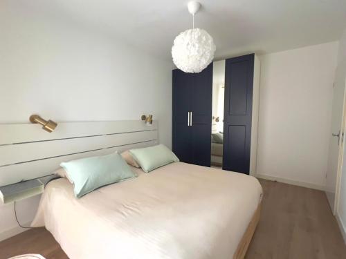 une chambre avec un lit blanc avec deux oreillers dans l'établissement Proche Paris - Appartement 2 chambres cozy et moderne, à Ivry-sur-Seine