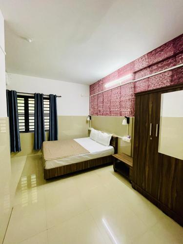 a small bedroom with a bed and a mirror at LAIBARESIDENCy in Panamaram