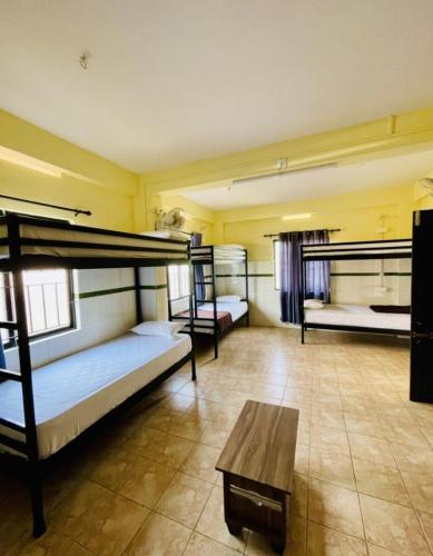 a room with three bunk beds and a table at LAIBARESIDENCy in Panamaram